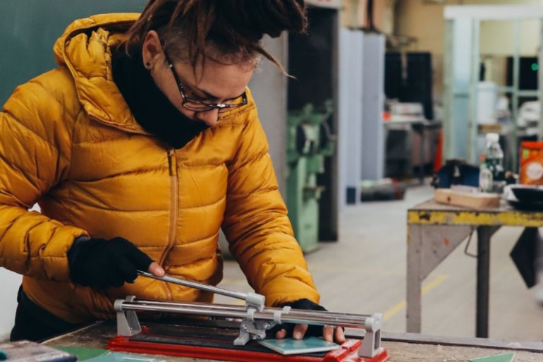 Elizabeth learning to cut tiles in the Habitat Women workshop