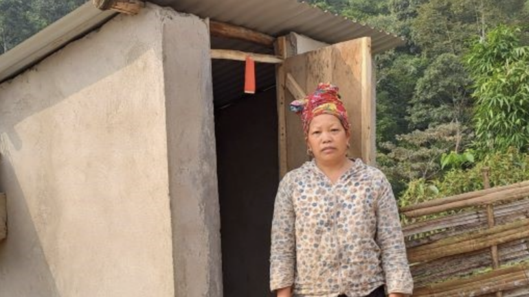 Mrs Tan Ta May stands in front the new toilet built outside her home.