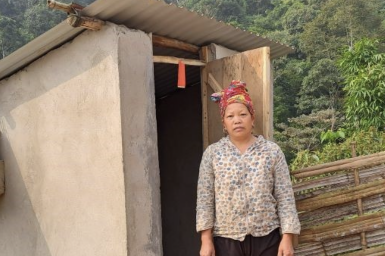 Mrs Tan Ta May stands in front the new toilet built outside her home.