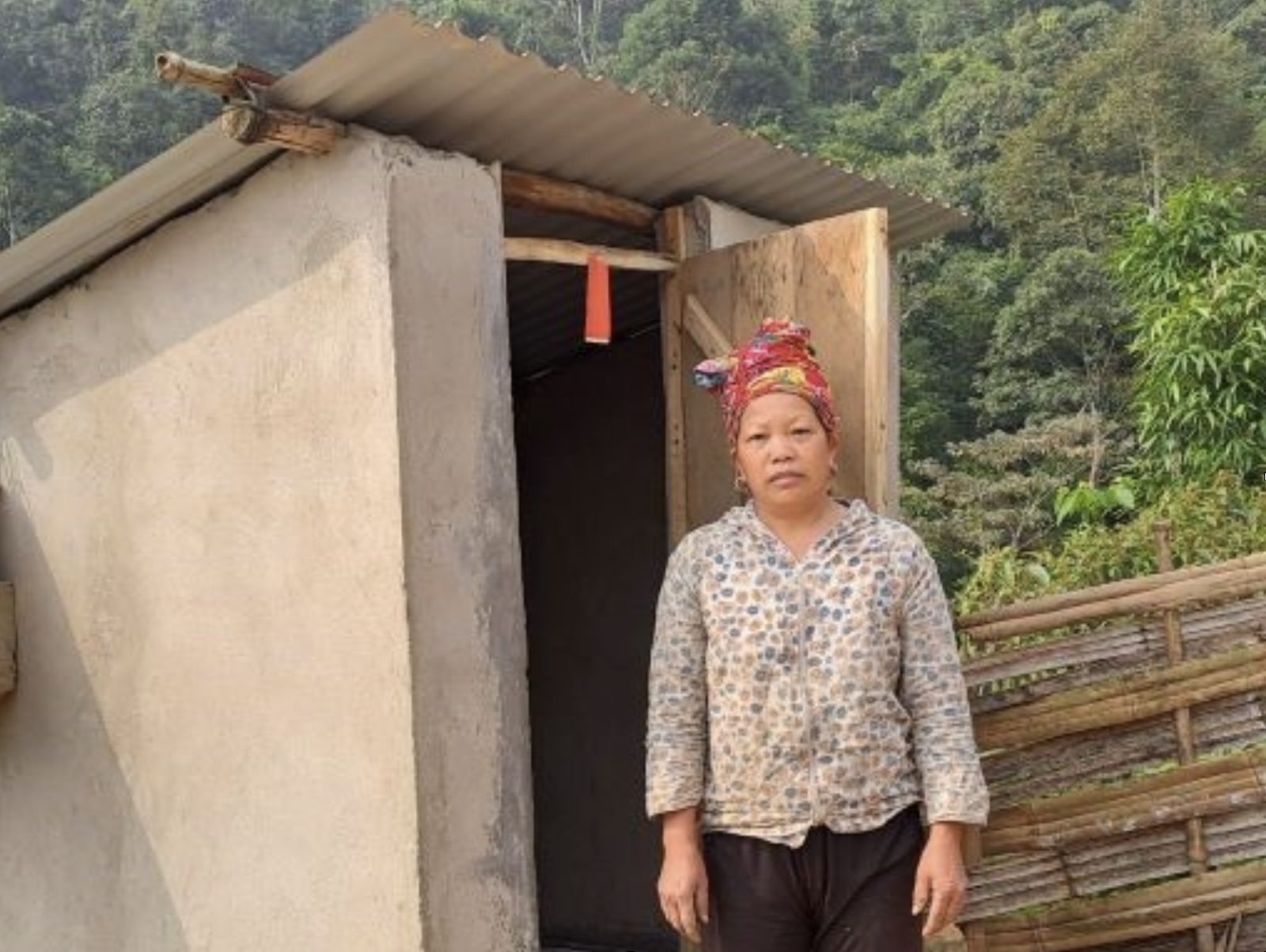 Mrs Tan Ta May stands in front the new toilet built outside her home.